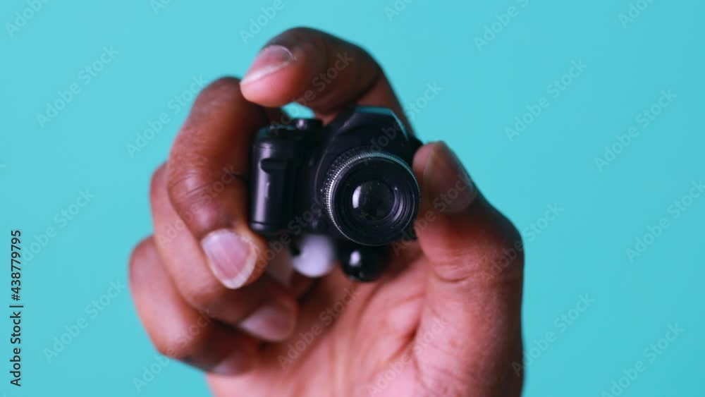 mini camera in hand of african american man in blue studio mini camera in hand of african american man in blue studio