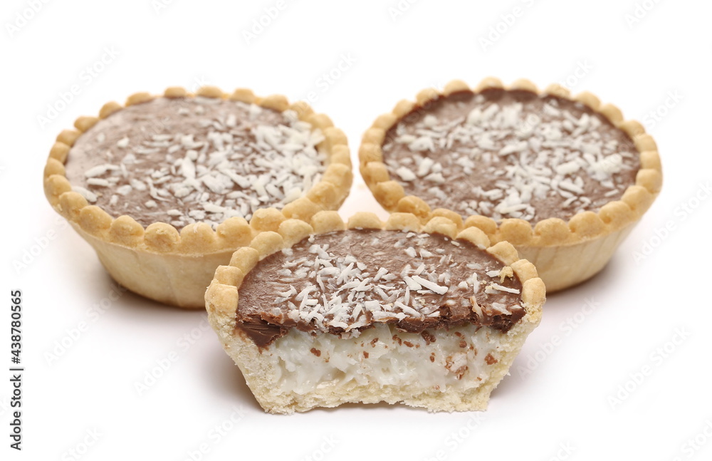 Mini chocolate tarts with coconut filling and shavings isolated on white background