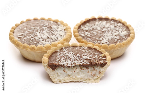 Mini chocolate tarts with coconut filling and shavings isolated on white background