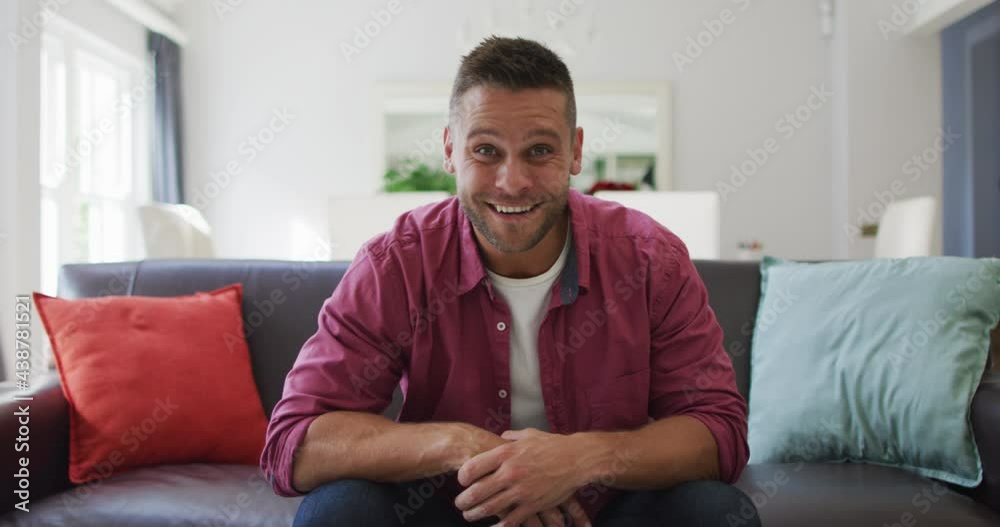 Happy caucasian man at home, sitting on couch making video call, talking and smiling