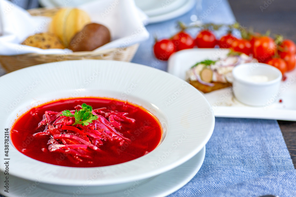 Beetroot soup, borscht, beautifully served in a white plate on the table in the restaurant. National Russian, Ukrainian cuisine. Restaurant menu Beetroot soup, borscht, beautifully served in a white plate on the table in the restaurant. National Russian, Ukrainian cuisine. Restaurant menu