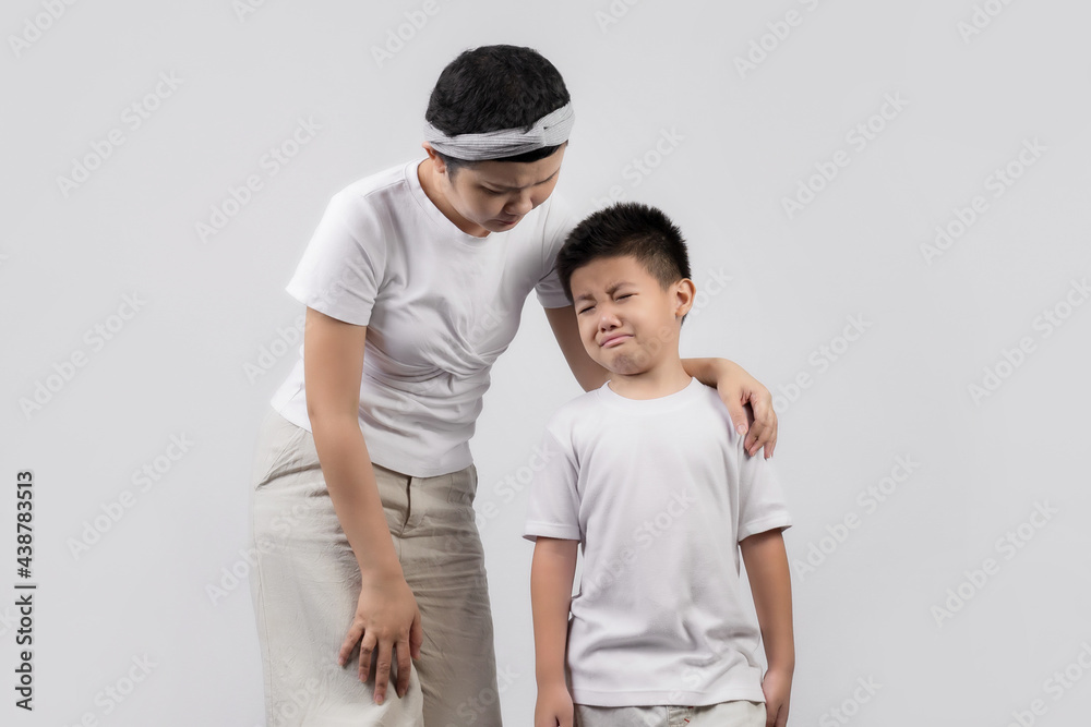 Young adult female cancer patient spending time with little son on gray background. Cancer and family support concept. Young adult female cancer patient spending time with little son on gray background. Cancer and family support concept.