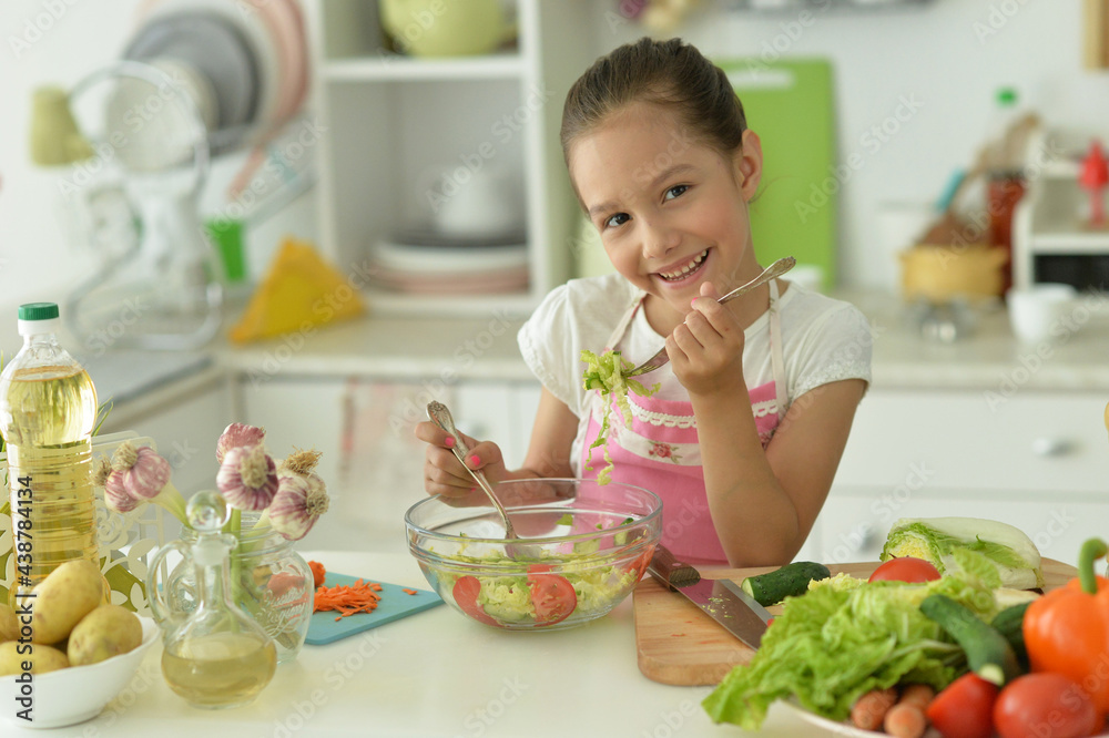 Cute girl preparing delicious fresh salad in kitchen Cute girl preparing delicious fresh salad in kitchen
