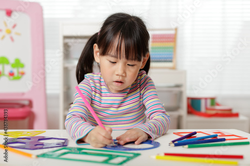 young girl drawing different shapes for homeschooling