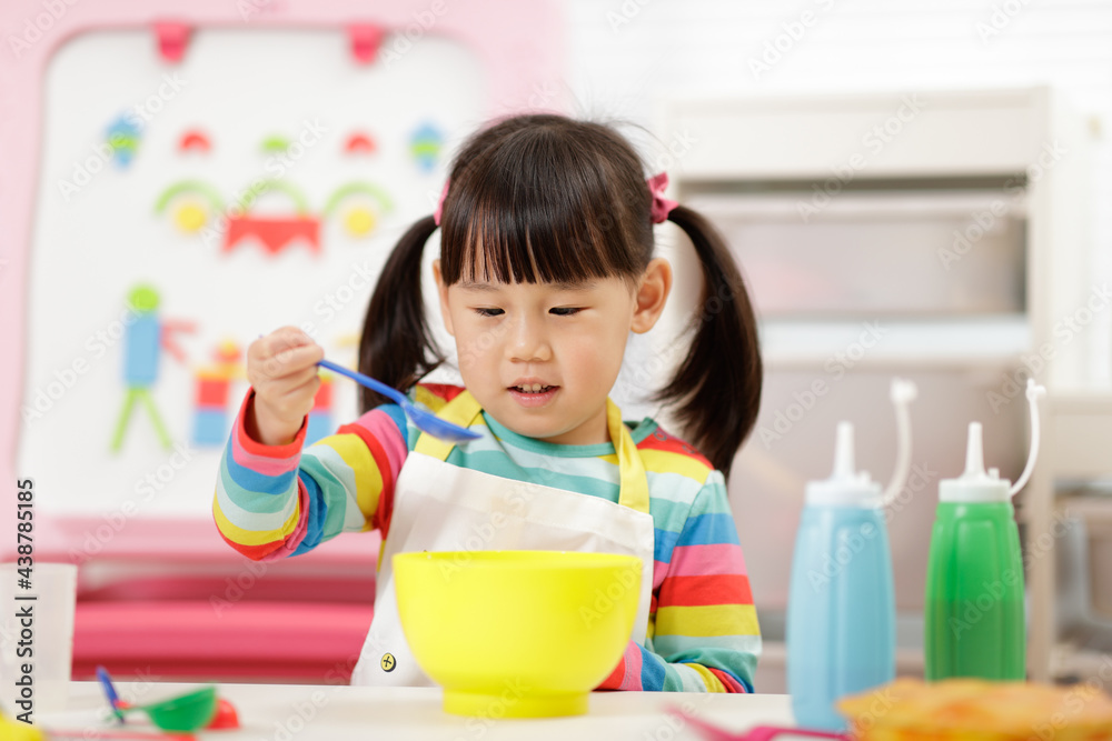 young girl pretend playing food preparing at home