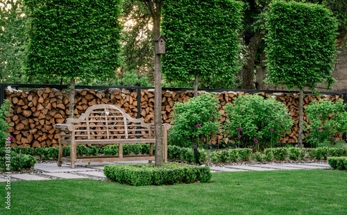 Piękny ogród z drewnianą ławeczką, nowoczesna forma ogrodu
