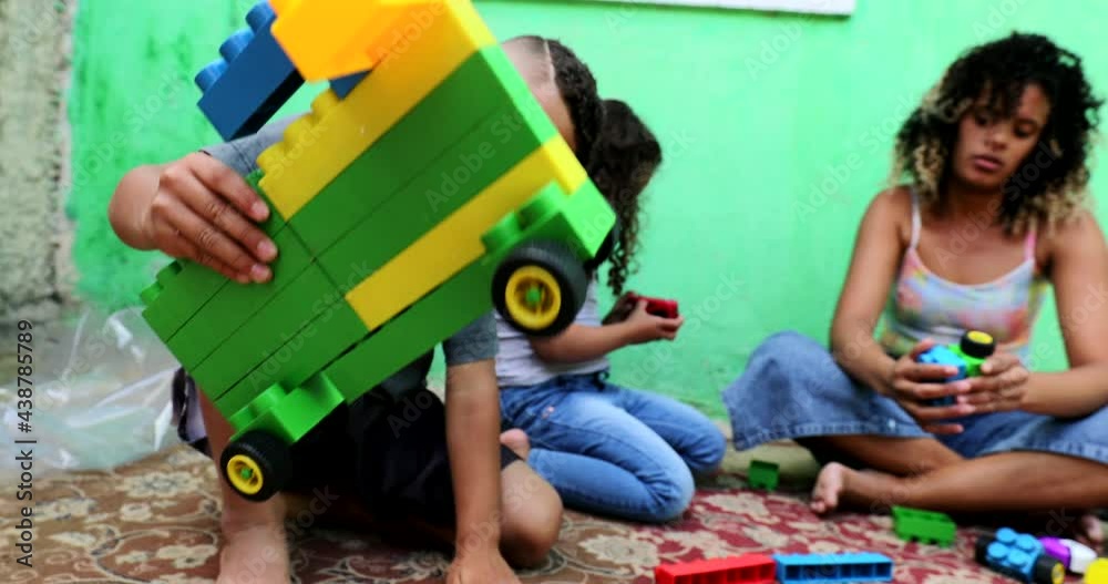 Hispanic children playing home with toys Hispanic children playing home with toys