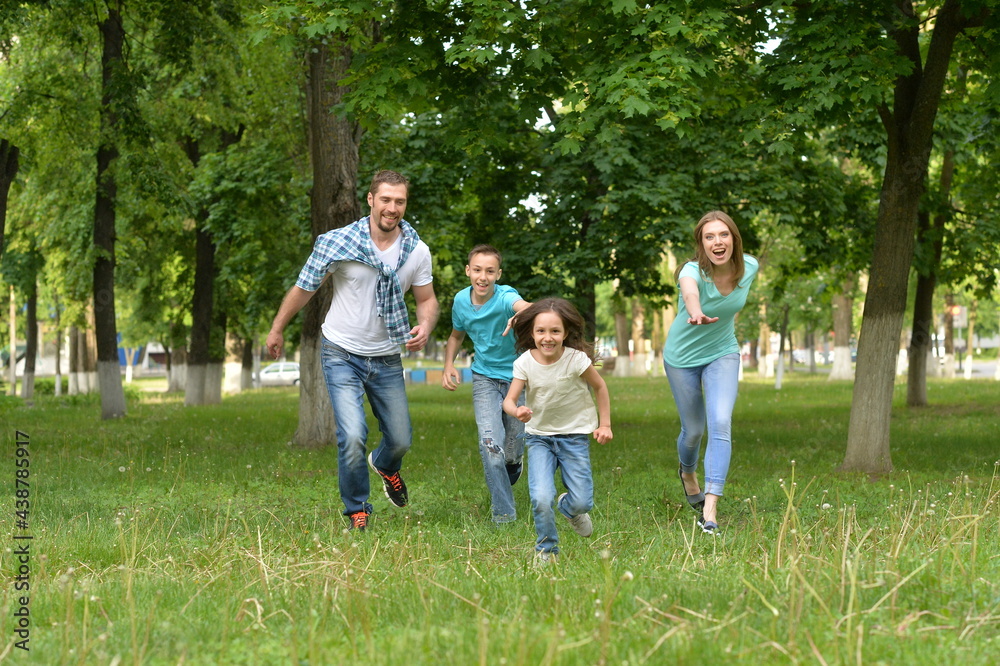 Portrait of happy young family  running in summer  park