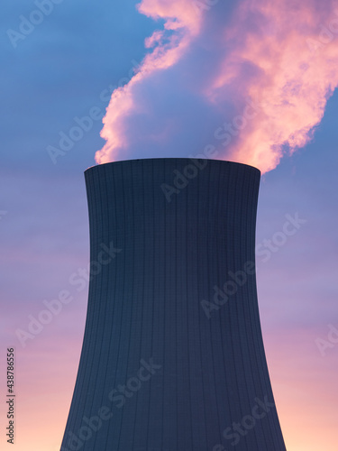 Nuclear power plant against sky at sunset photo