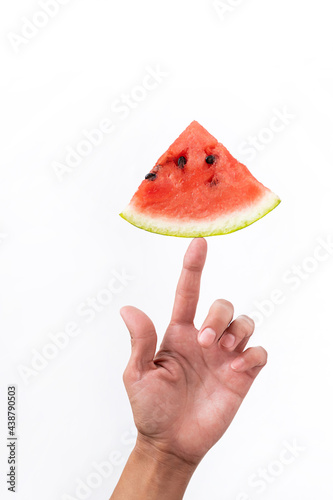 Red watermelon piece in female hand. Creative summer concept. Minimal composition of summer fruit on white background.