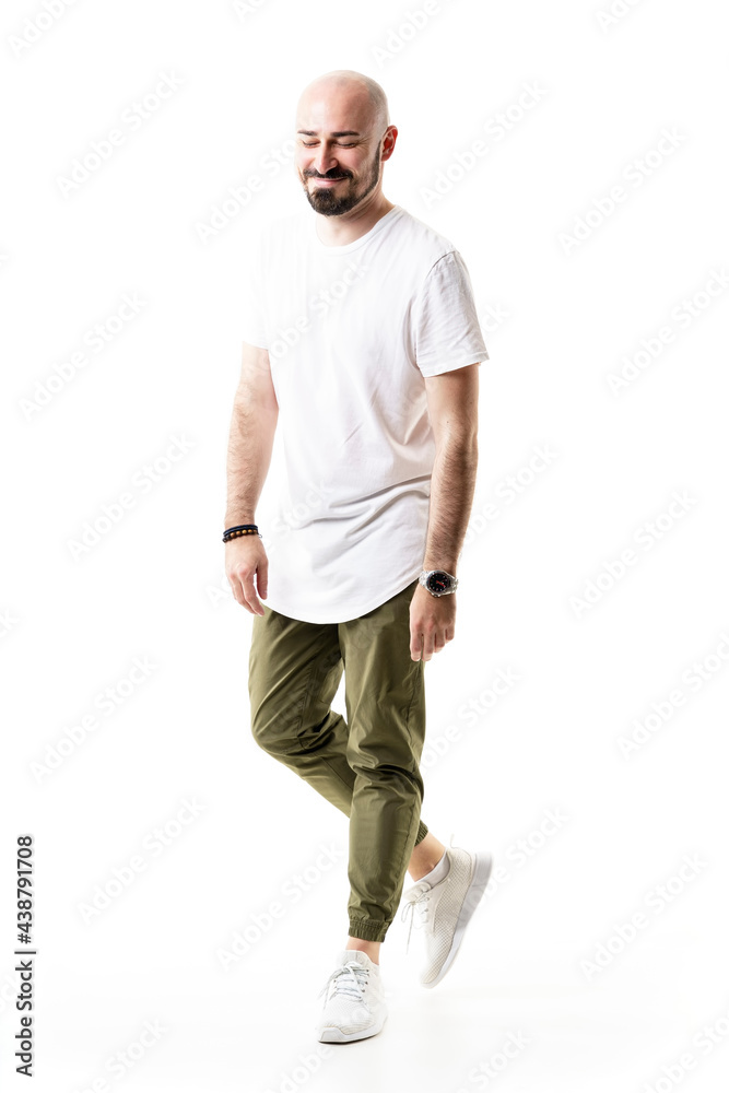 Candid happy young bald bearded man smiling with closed eyes and arms down. Full body length isolated on white background Candid happy young bald bearded man smiling with closed eyes and arms down. Full body length isolated on white background