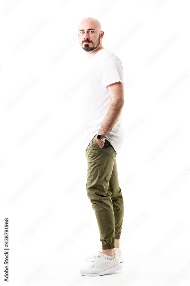 Side view of standing young bald shaven man in chino trousers. Full body length isolated on white background Side view of standing young bald shaven man in chino trousers. Full body length isolated on white background