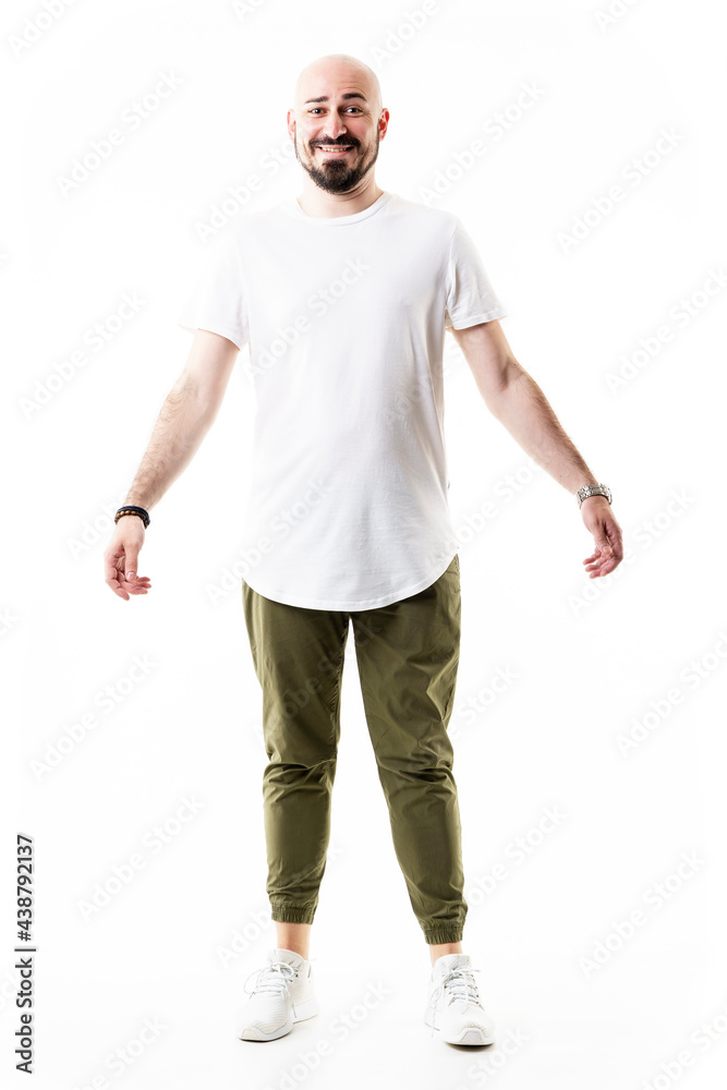 Candid smiling bald bearded stylish hipster in olive chinos. Full body length isolated on white background Candid smiling bald bearded stylish hipster in olive chinos. Full body length isolated on white background