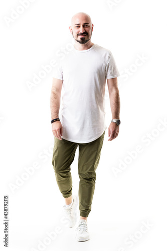 Happy walking bald bearded man in olive green pants and blank white shirt. Full body length isolated on white background