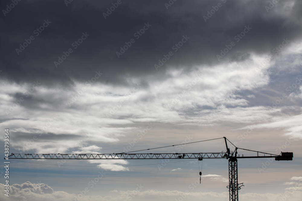 Silhouette of a crane on a gray sky background