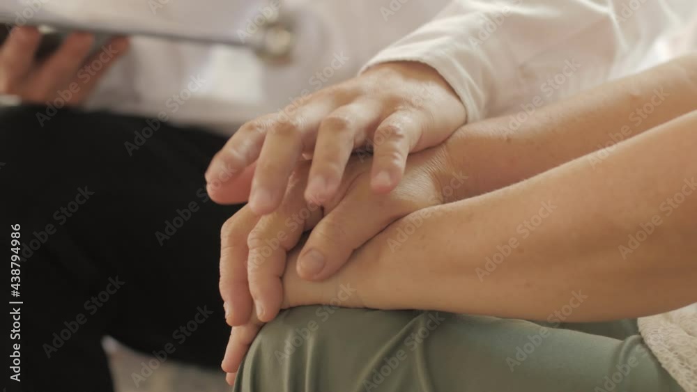 Male doctor nurse wearing white uniform shakes hands of senior grandmother patient Male doctor nurse wearing white uniform shakes hands of senior grandmother patient