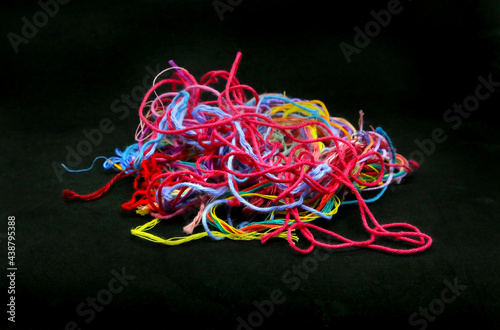Multicolored tangled threads for needlework close-up on black background