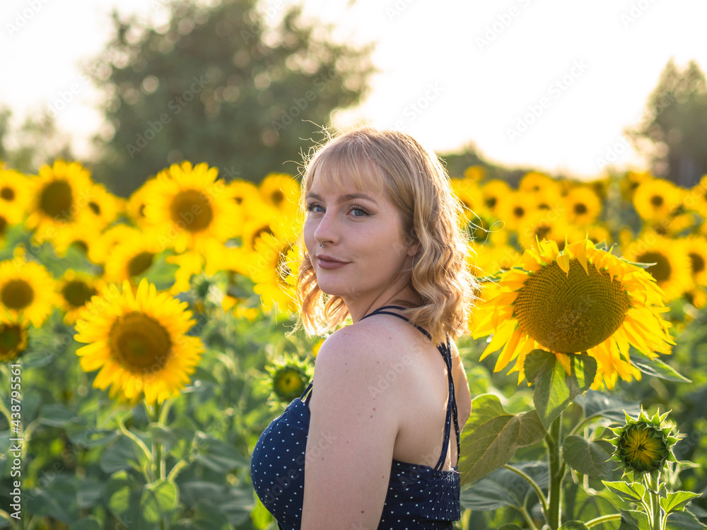 Mujer joven y guapa disfrutando de la primavera o verano en un campo de girasoles Mujer joven y guapa disfrutando de la primavera o verano en un campo de girasoles