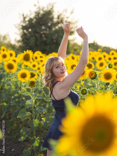 Mujer joven guapa disfrutando de las flores en un campo de girasoles