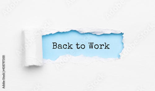 The text back to work appearing behind torn yellow paper