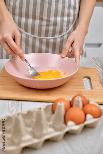 Woman beats eggs in a bowl. housewife cooking on kitchen