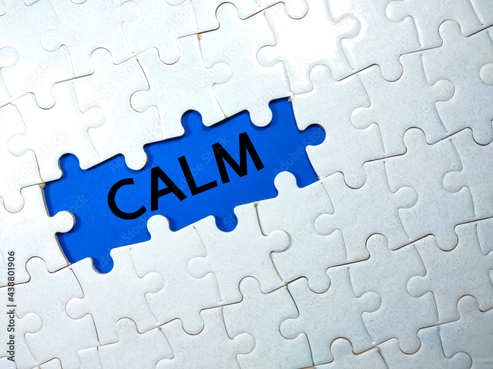 Selective focus.Text CALM with jigsaw puzzle on blue background. Selective focus.Text CALM with jigsaw puzzle on blue background.
