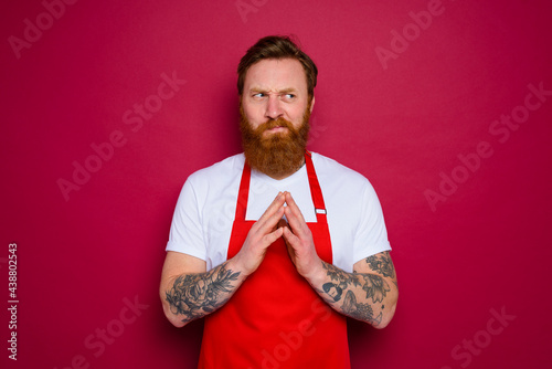 doubter isolated chef with beard and red apron © alphaspirit