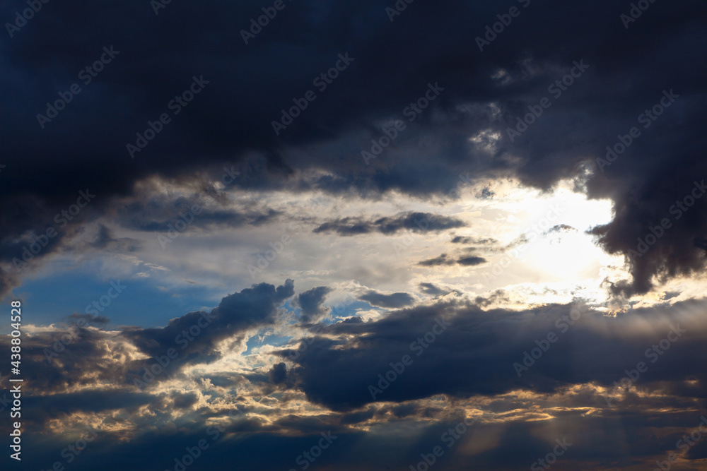 Obraz premium Sun shining through dark clouds . Sunlight rays and cloudy heaven