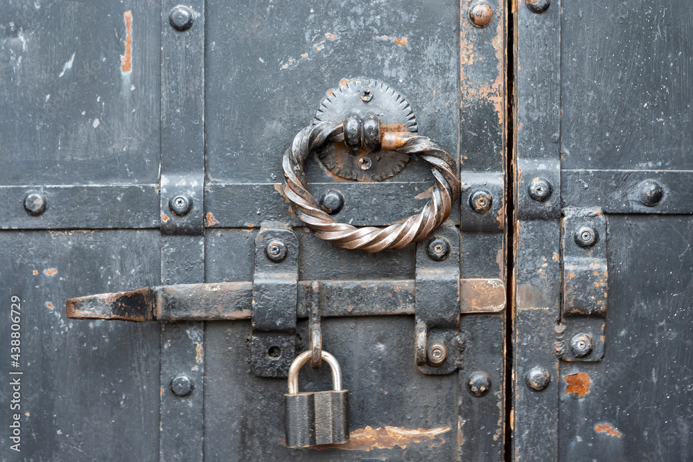 Fototapeta premium Padlock is hinged on latch of old door.