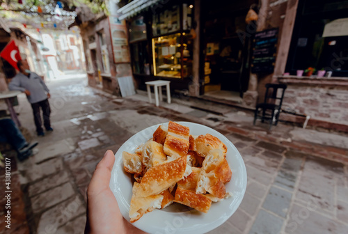 Breakfast with traditional turkish borek food on street with bars and local cafes. Turkish dish. photo