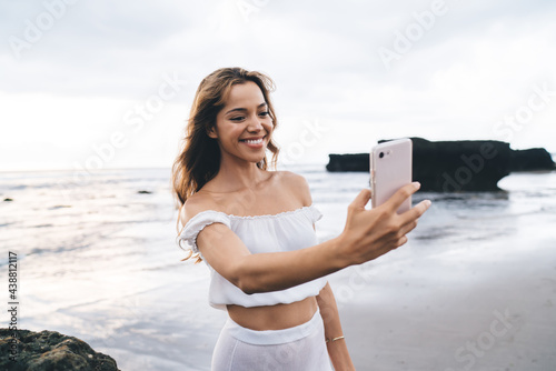 Cheerful woman taking selfie against sea © BullRun