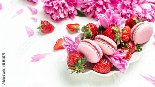 Delicious many peony flowers, macarons and sweet strawberry. Small French cakes with fruit
