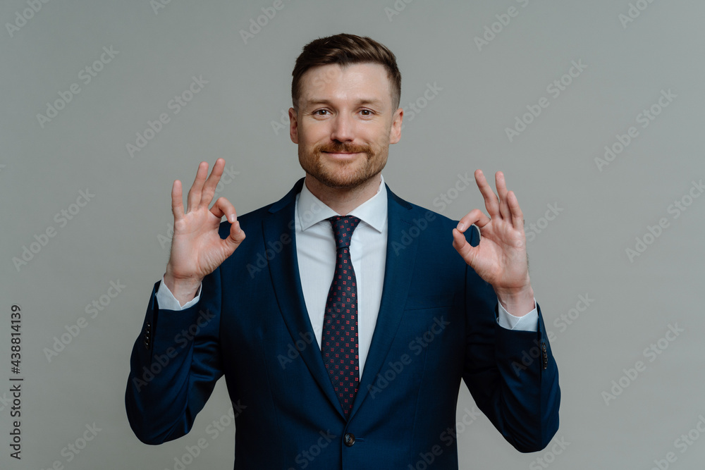 Happy businessman in suit showing that everything is ok