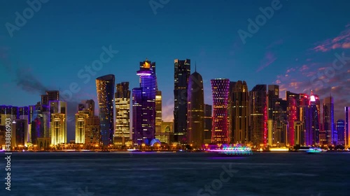 The skyline of Doha. Doha at night Time-lapse, Qatar. Wide shot, Modern skyscrapers and towers with the sea at night. Tall buildings city center Time-lapse video, Middle East.