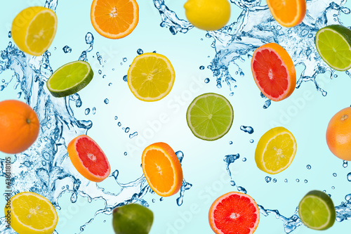 Minimal idea with sliced orange, lemon, lime and grapefruitwith water splash on a blue background.