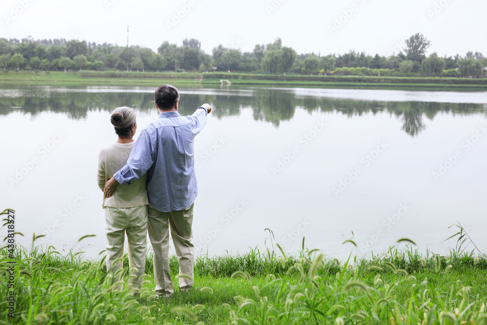 Happy old couple watching the scenery by the lake Happy old couple watching the scenery by the lake