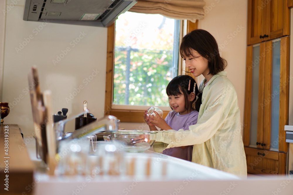 お母さんと一緒に料理をする女の子