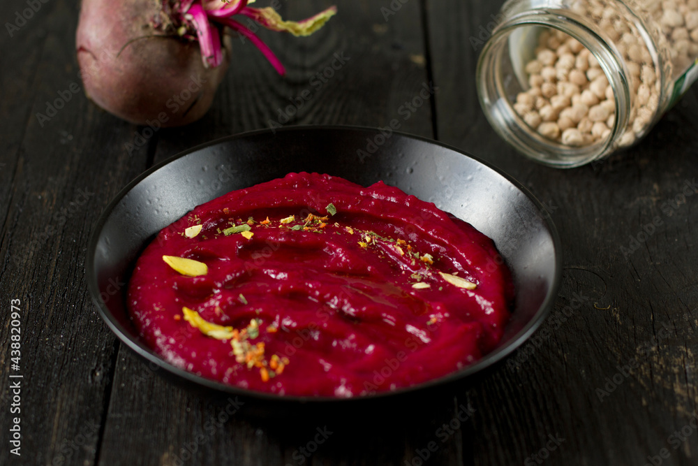 Delicious vegetarian beetroot hummus in a black plate Delicious vegetarian beetroot hummus in a black plate