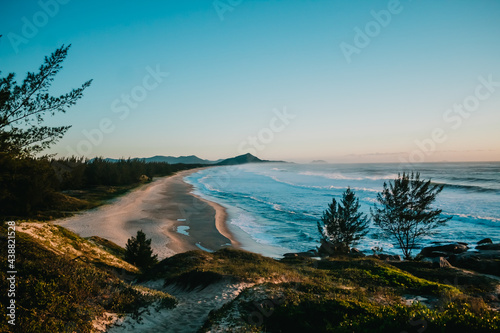 Day dawning and the sea hitting the sand with blue sky in Gamboa, a Brazilian beach in Garopaba - SC