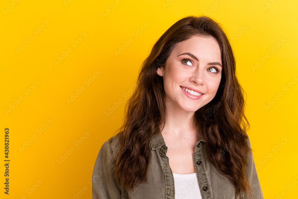 Photo of adorable lady toothy smile look interested empty space thinking isolated on yellow color background Photo of adorable lady toothy smile look interested empty space thinking isolated on yellow color background