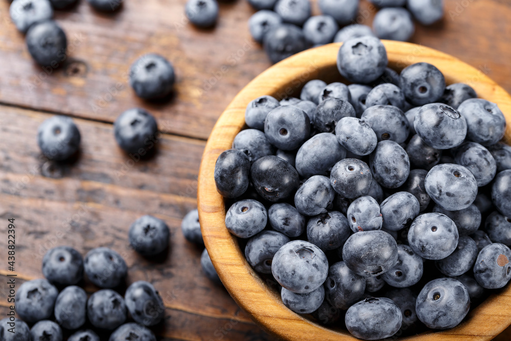 Freshly picked blueberries in wooden bowl on a wooden table. Freshly picked blueberries in wooden bowl on a wooden table.