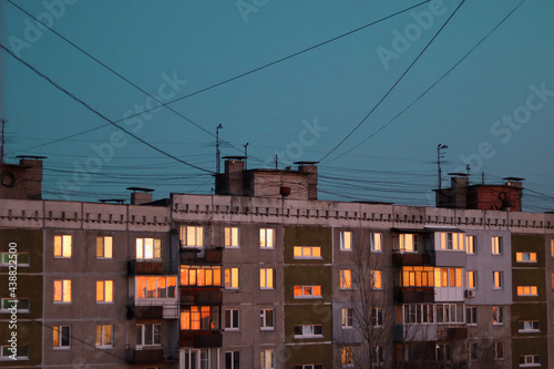 windows reflecting the sunset sky, soviet building, wires on the sky background © Madina Valemeeva