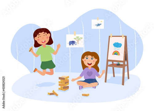 Two little kids are playing jenga in a cute playroom interior together