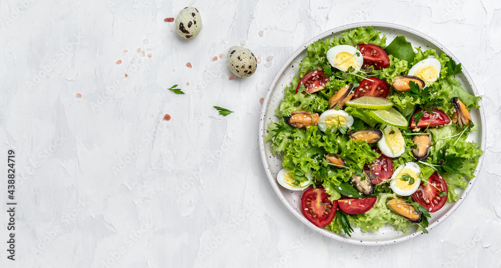 Salad with mussels, quail, egg, conjugate lime, spinach, lettuce, cherry tomatoes and microgreen. Dietary salad. Long banner format. top view