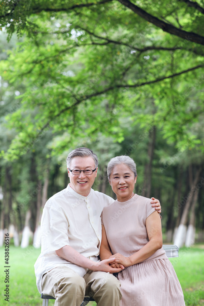 Happy old couple sitting on chairs in outdoor park Happy old couple sitting on chairs in outdoor park
