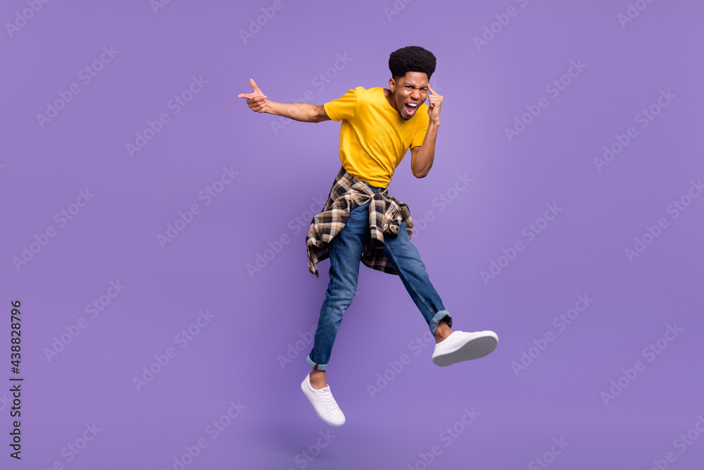 Full length body size view of attractive cheery cool guy jumping having fun showing mind isolated over violet purple color background