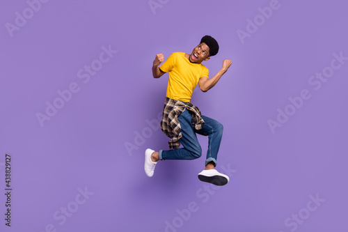 Full length body size view of attractive cheerful successful guy jumping celebrating isolated over violet purple color background © deagreez