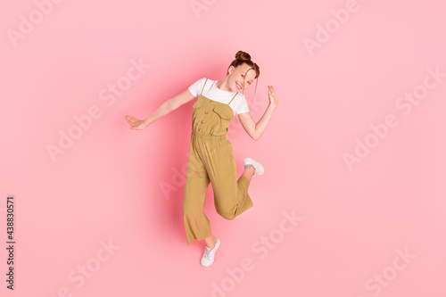 Full length body size view of attractive cheerful girl dancing having fun rest isolated over pink pastel color background