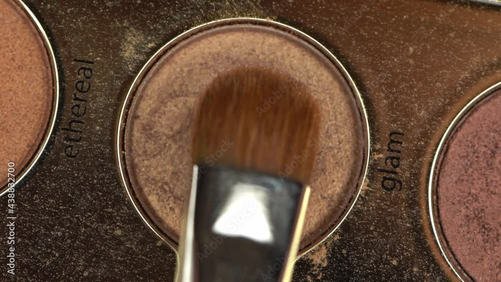 top view of cosmetic brush near brown eye shadow with glam lettering