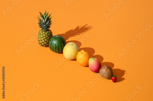 Fototapeta Naklejka Na Ścianę i Meble -  Summer fruits in bright light aligned on an orange background.